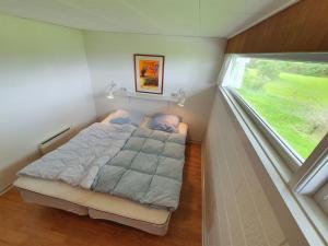 a small bedroom with a bed and a window at Holiday Home Thara - 100m from the sea in SE Jutland by Interhome in Sønderby