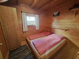 um pequeno quarto com uma cama num chalé de madeira em Chalet Nasenalmhütte by Interhome em Hippach