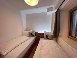 two beds in a small room with a window at Apartment Kleines Bergblick 15 by Interhome in Söll