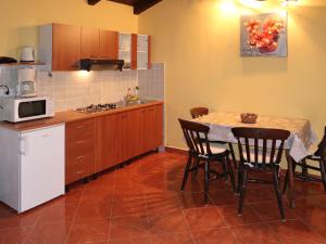 uma cozinha com uma mesa com cadeiras e um micro-ondas em Holiday Home Milena - LBN354 by Interhome em Barban