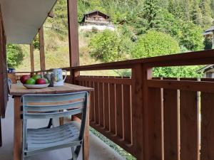 a wooden balcony with a table and a chair at Apartment Résidence 25 by Interhome in Champex