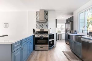 a kitchen with blue cabinets and a stove at Fire pit ~ Game Room ~ near NYC ~ Modern Luxury in New Rochelle
