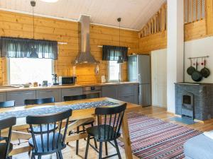 een keuken met een grote houten tafel en stoelen bij Holiday Home Koppelomaa by Interhome in Puolanka