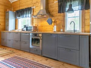 een keuken met grijze kasten en een fornuis bij Holiday Home Koppelomaa by Interhome in Puolanka