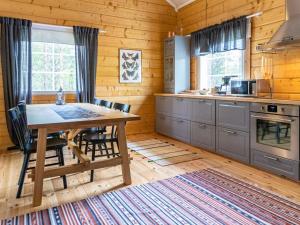 a kitchen with a table and chairs in a cabin at Holiday Home Koppelomaa by Interhome in Puolanka