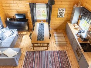 a living room with a table in a log cabin at Holiday Home Koppelomaa by Interhome in Puolanka