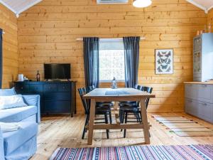 a dining room with a table and chairs at Holiday Home Koppelomaa by Interhome in Puolanka +32 photos
