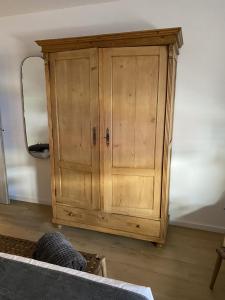einen Holzschrank in einem Zimmer mit Spiegel in der Unterkunft Weinquartier11 in Bernkastel-Kues