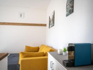 een woonkamer met een gele bank en een tv bij Studio Beau séjour 15 by Interhome in Ovronnaz