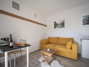 een woonkamer met een bank en een tafel bij Studio Beau séjour 15 by Interhome in Ovronnaz