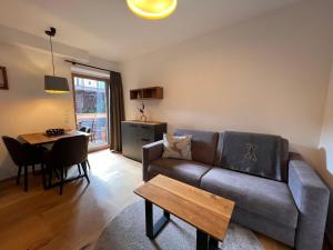 a living room with a couch and a table at Apartment Kleines Bergblick 09 by Interhome in Söll