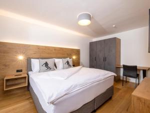 a bedroom with a large bed and a desk at Apartment Deluxe Bergblick 10 by Interhome in Söll