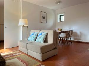ein Wohnzimmer mit einem Sofa und einem Tisch in der Unterkunft Casa do Tanque in Vila Nova de Famalicão
