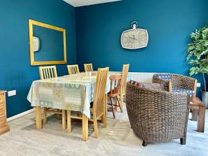 comedor con mesa, sillas y reloj en Crocus Cottage en York