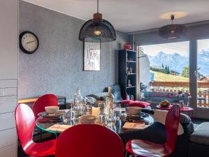 a dining room with a table and red chairs at Apartment Victoria 1 D2 by Interhome in Nendaz