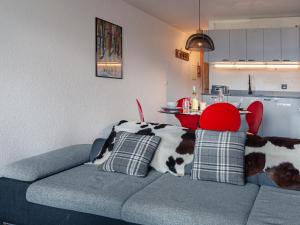a blue couch with a cow pillow on it in a kitchen at Apartment Victoria 1 D2 by Interhome in Nendaz