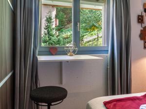 a bedroom with a window and a stool in front of it at Apartment Victoria 1 D2 by Interhome in Nendaz