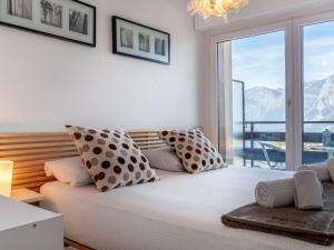 a bedroom with a large bed with a large window at Apartment Olympic C7 by Interhome in Nendaz