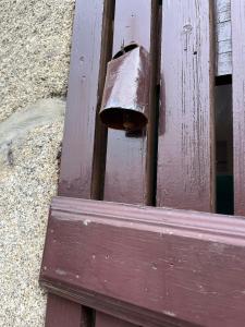 a wooden door with a metal bell on it at Casa do Tanque in Vila Nova de Famalicão