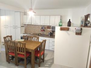 a kitchen with white cabinets and a wooden table and chairs at TAMBO LIBERTADOR in San Juan