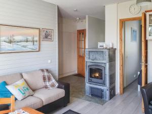 a living room with a couch and a fireplace at Holiday Home Moitakuru a6 by Interhome in Saariselka