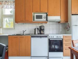 a kitchen with a white stove and a microwave at Holiday Home Moitakuru a6 by Interhome in Saariselka