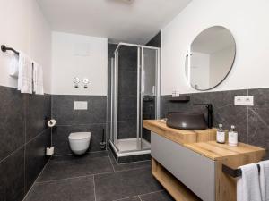 ein Badezimmer mit einem Waschbecken, einem WC und einem Spiegel in der Unterkunft Apartment Apartments Austria-8 by Interhome in Söll