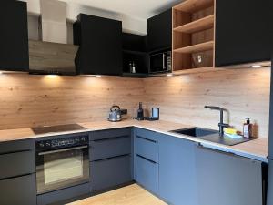 eine Küche mit schwarzen Schränken und einem Waschbecken in der Unterkunft Apartment Apartments Austria-8 by Interhome in Söll