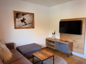 a living room with a couch and a flat screen tv at Apartment Comfort Bergblick 13 by Interhome in Söll +22 photos