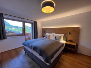 ゼルにあるApartment Comfort Bergblick 13 by Interhomeの大きなベッドと大きな窓のある寝室