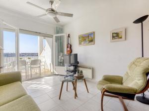 een woonkamer met een bank en stoelen en een balkon bij Apartment Sant Maurici by Interhome in Empuriabrava
