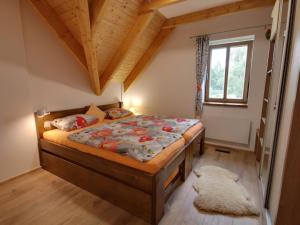 um quarto com uma cama num quarto com tecto em madeira em Holiday Home Chalupa U Krále by Interhome em Kořenov