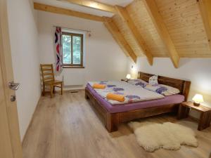a bedroom with a bed and a chair and a window at Holiday Home Chalupa U Krále by Interhome in Kořenov