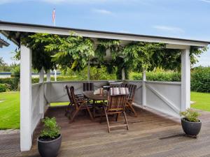 un patio con mesa y sillas en una terraza en Holiday Home Ilsebil - 250m from the sea in SE Jutland by Interhome, en Juelsminde
