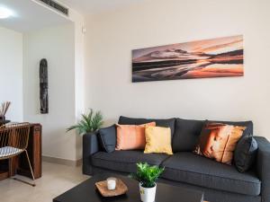 een woonkamer met een grijze bank met kussens bij Apartment Cielo y mar Samara-2 by Interhome in Marbella