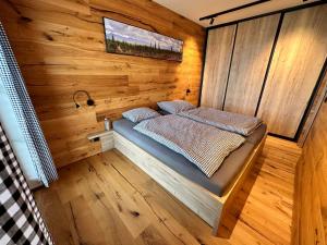 1 dormitorio pequeño con 1 cama en una pared de madera en Holiday Home Říčky v Orlických horách E34 by Interhome, en Říčky