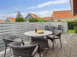 a patio with a table and chairs and a fence at Holiday Home Ravn - 3-3km from the sea in Bornholm by Interhome in Vester Sømarken
