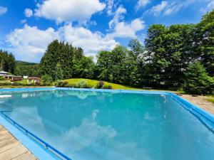 a large swimming pool with blue water at Chalet Lux chalet by Interhome in Mladé Buky