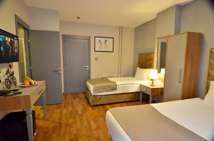 um quarto de hotel com duas camas e uma secretária em Cadde 7 Otel em Ancara
