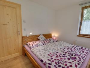 a bedroom with a bed with a purple and white comforter at Apartment U Krále-2 by Interhome in Kořenov