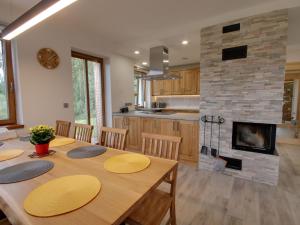 a kitchen with a wooden table and a fireplace at Apartment U Krále-2 by Interhome in Kořenov