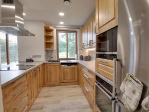 a kitchen with wooden cabinets and a refrigerator at Apartment U Krále-2 by Interhome in Kořenov