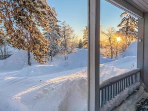 un porche recouvert de neige avec le soleil en arrière-plan dans l'établissement Holiday Home Saariseläntie 8 a 8 by Interhome, à Saariselka