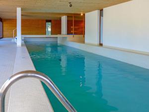 ein Pool mit blauem Wasser in einem Gebäude in der Unterkunft Studio Jeanne d'Arc-14 by Interhome in Crans-Montana