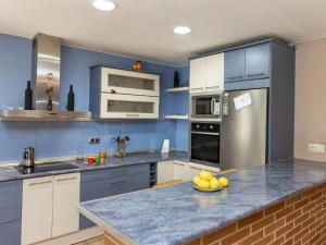 una cocina con paredes azules y una barra con un bol de fruta en Holiday Home Dolce by Interhome en Caldes de Malavella