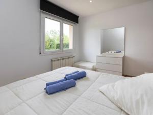 una camera da letto con un grande letto bianco con cuscini blu di Holiday Home Dolce by Interhome a Caldes de Malavella