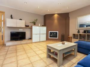 ein Wohnzimmer mit einem blauen Sofa und einem TV in der Unterkunft Holiday Home Dolce by Interhome in Caldes de Malavella