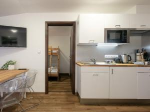 uma cozinha com armários brancos e uma bancada em Apartment U Kabinky 5-0 by Interhome em Janske Lazne