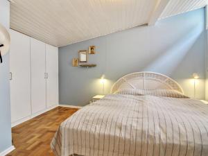 a bedroom with a large bed and a blue wall at Apartment Heidel - 400m from the sea in NW Jutland by Interhome in Skagen