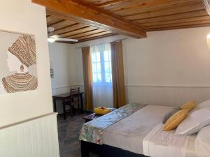 a bedroom with a bed and a table and a window at Saint Leu - Gîte Ylang Ylang - Bardzour in Saint-Leu